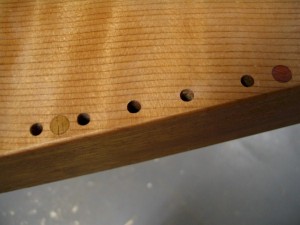 1/4" wooden plugs are inlaid flush with the soundboard to mark the locations of specific notes